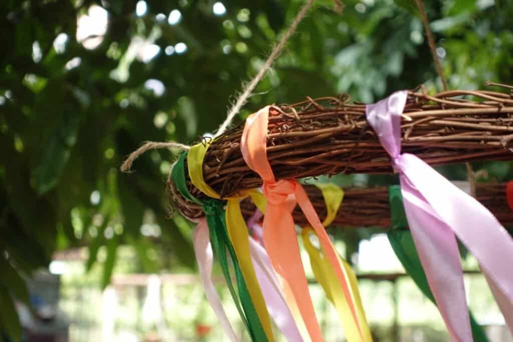 Colorful ribbons on a woven outdoor play structure for children.